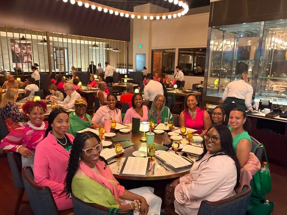 Sorors sharing a meal around a restaurant table