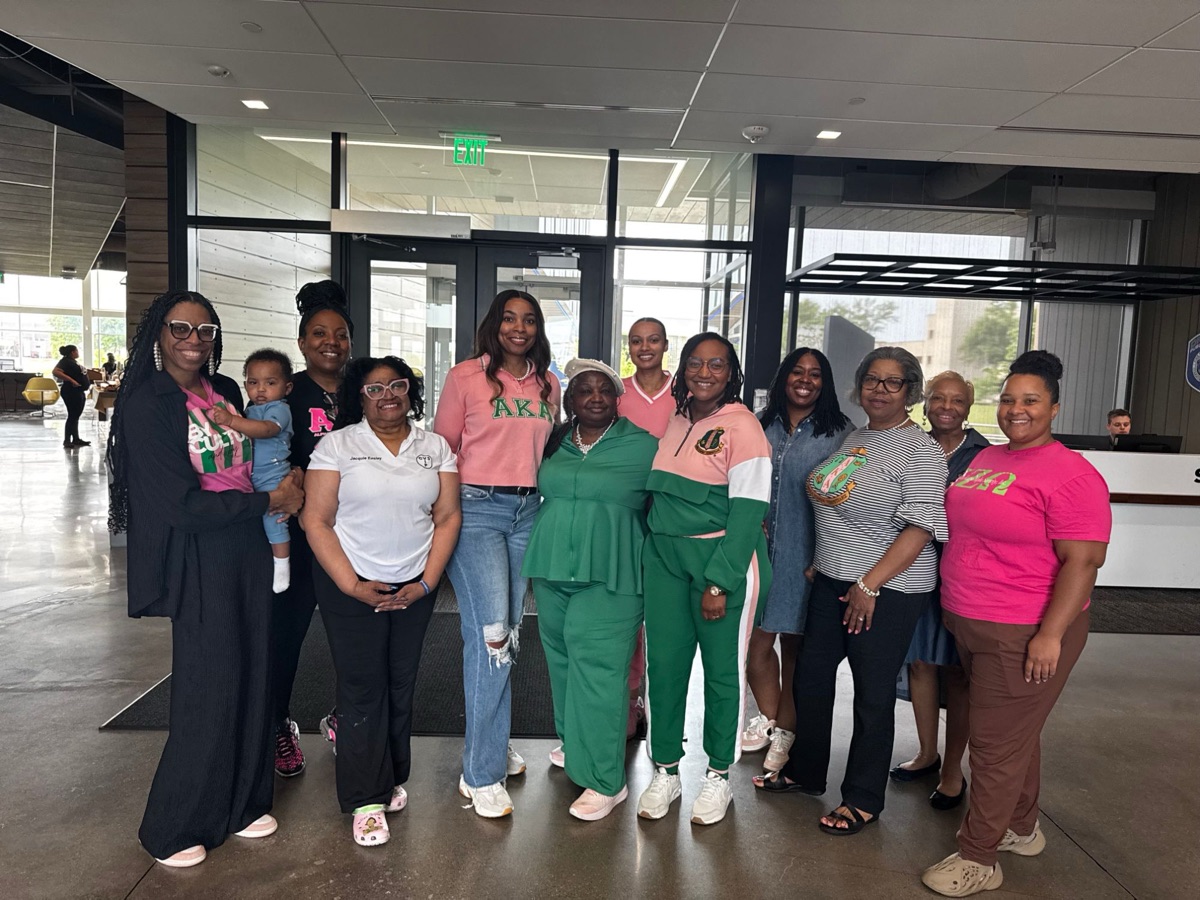Sorors in pink and green gathered in a lobby