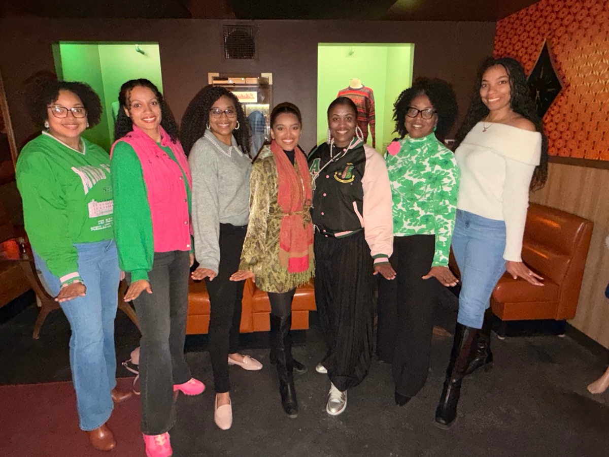 Seven sorors posing together in a lounge